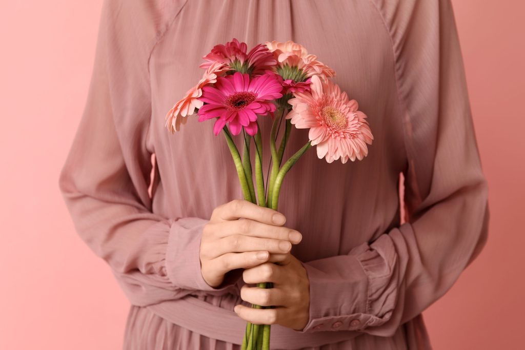 Person holding gerbera daisies