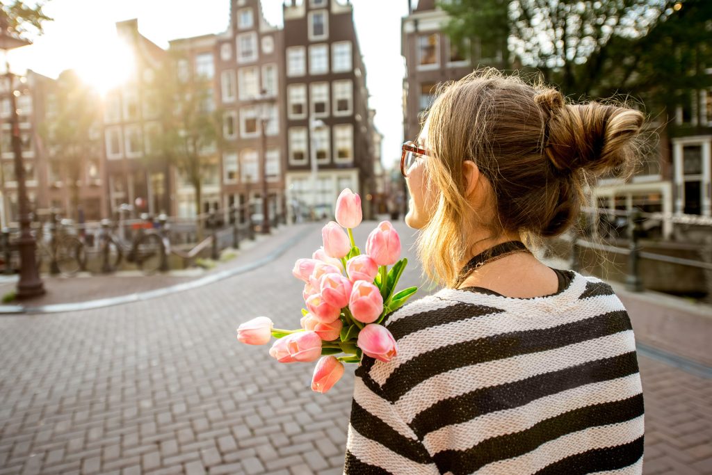 Person holding a bouquet of pink tulips